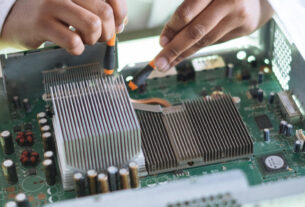 A technician is working on the electrical circuit with tester in hands.