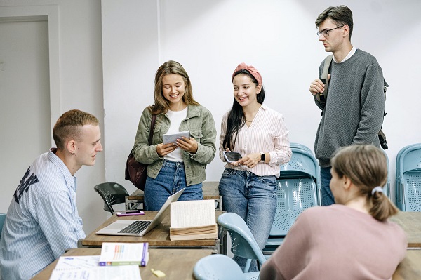 Four students who have come for the industrial visit, listening to the head person of a company.